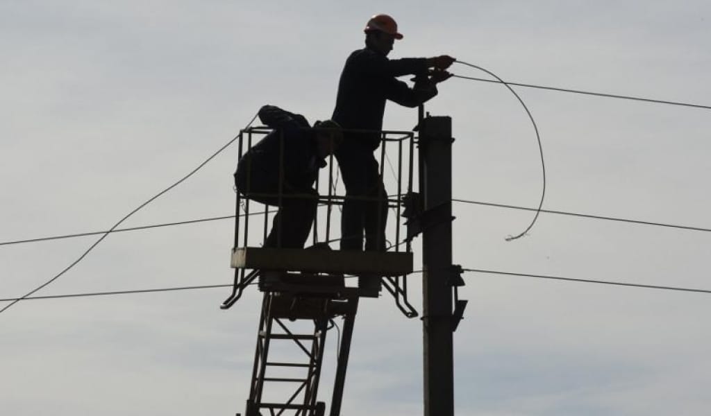 АЛАКӨЛДЕ ЭЛЕКТР ЖЕЛІЛЕРІН ЖӨНДЕП ЖАТҚАН ЕКІ ЖҰМЫСШЫ КӨЗ ЖҰМДЫ